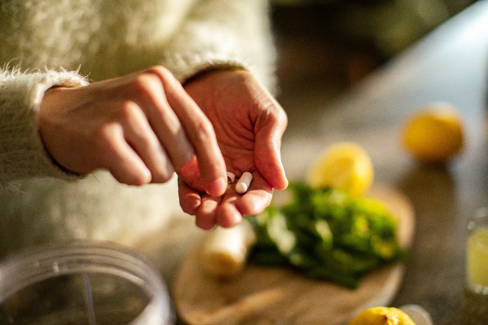 A hand taking a capsule pill